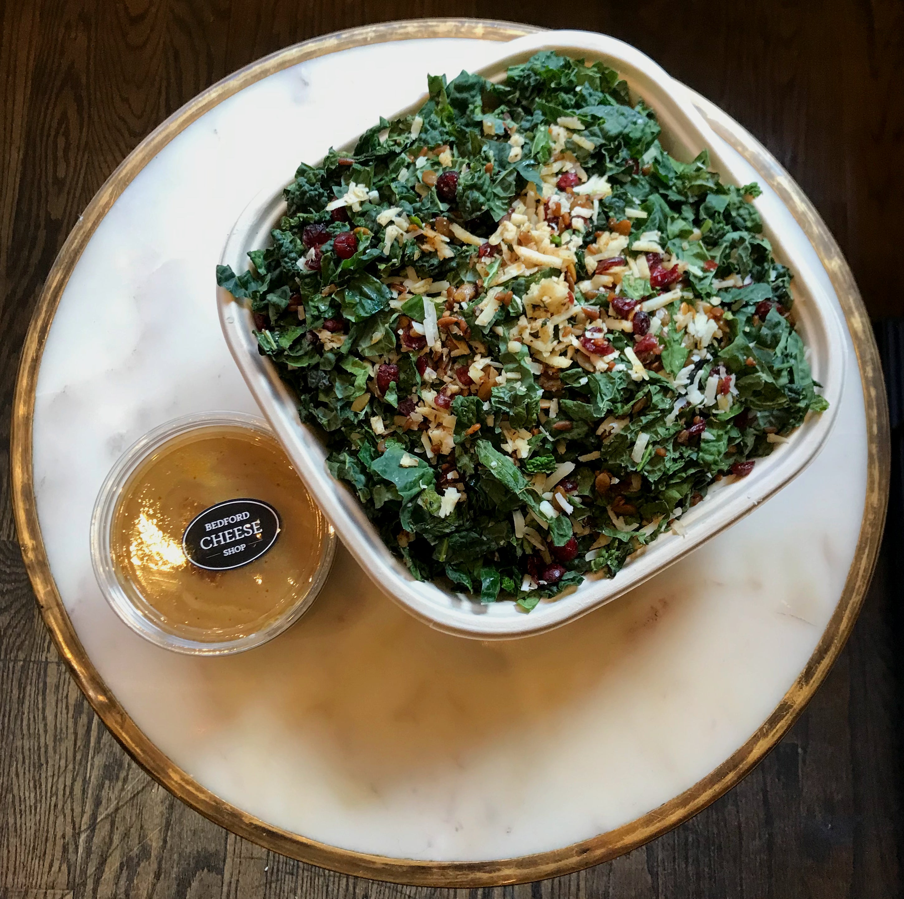 Image taken from above of the Kale Manchego salad with dressing on the side. 