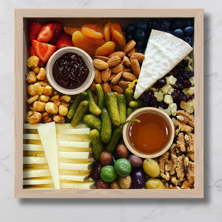 Image is of the two cheese board on top of a marble surface.