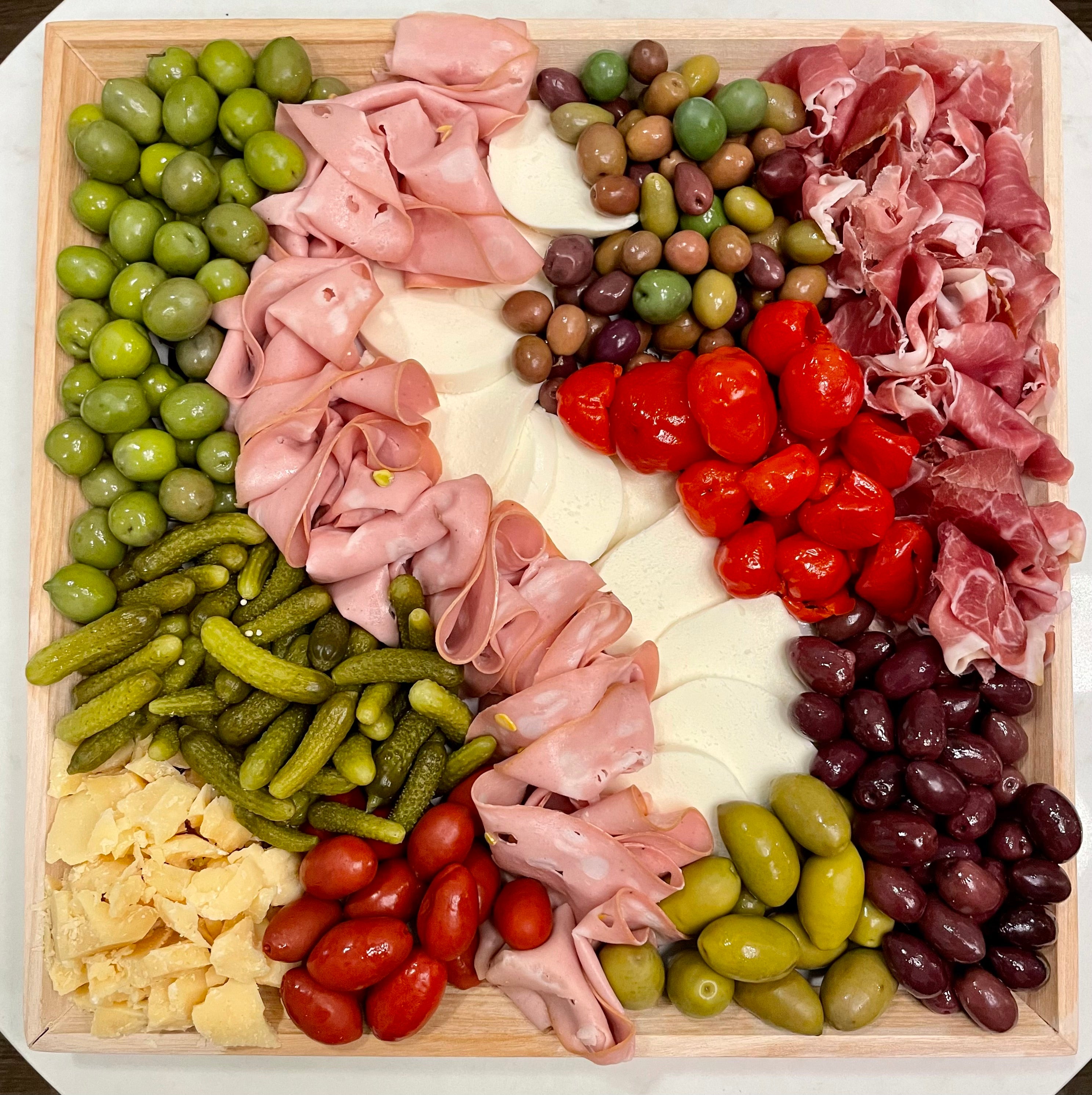 Image of large antipasto platter. Seasonal cheeses and cured meats served with hearty hel[pings of antipasto (assorted olives, pickled peppers, and cornicons). Small platter pricing  $123 large platter pricing $163 plus taxes and fees.